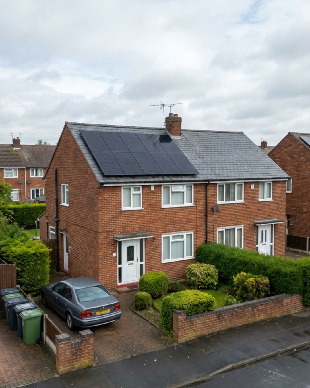 UK semi-detached home with solar panels on the roof on a cloudy day